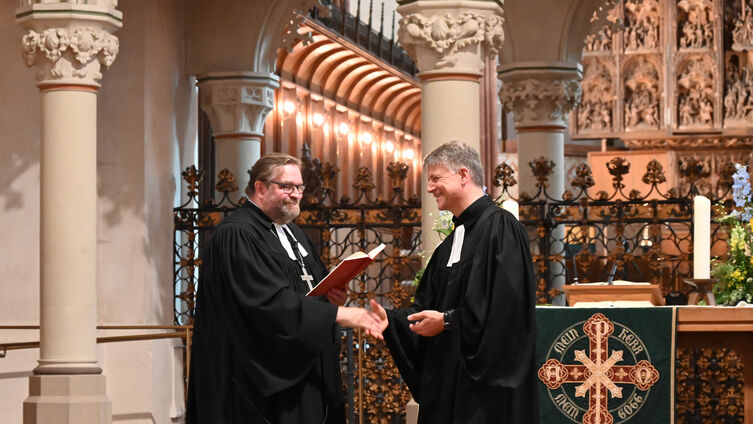 Propst Helgo Jacobs (links) entpflichtet Pastor Dr. Michael Dübbers von seinen Aufgaben in der Kirchengemeinde Schleswig. Foto: Ahrens