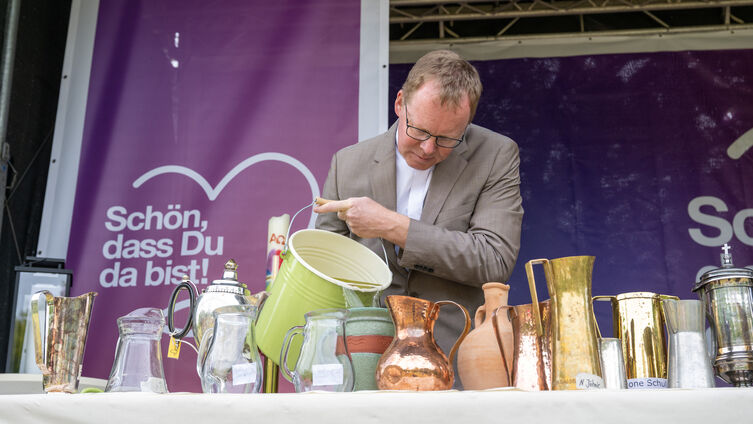 Tauffest-Pastor Kai Hansen gießt Schleiwasser in die Tauf-Kannen / Foto: Tim Riediger 