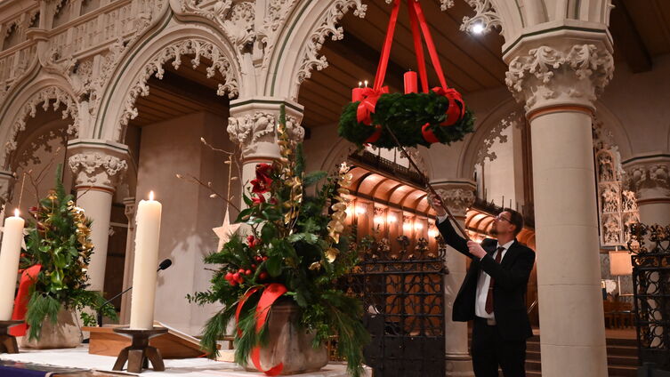 Domküster Tim Schröder entzündet die erste Kerze am Adventskranz