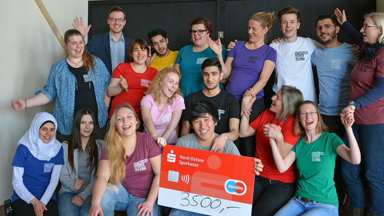 12 Jugendliche und das Projektteam freuen sich uber Nospa Spende von Heiko Ewert winkend hinten links Foto Pfaff