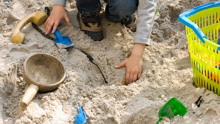 Kind spielt Sandkasten