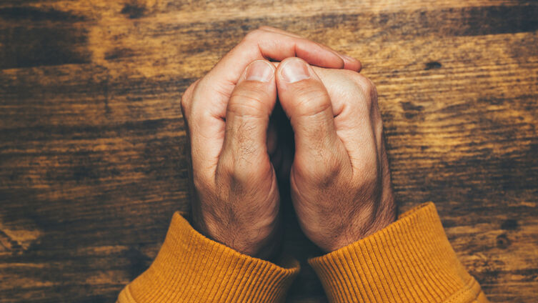Top view of religious male crossed hands in prayer