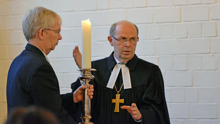 Bischof uebergibt Kerze an Henning Luethke Foto Pfaff